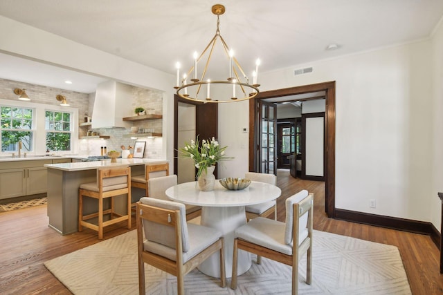 dining room featuring an inviting chandelier, hardwood / wood-style floors, and sink