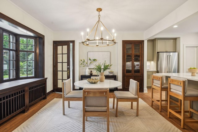 dining area featuring a notable chandelier and light wood-type flooring