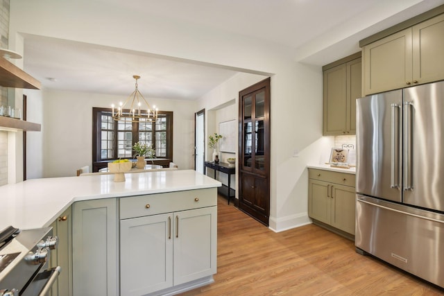 kitchen featuring decorative light fixtures, light hardwood / wood-style flooring, stainless steel appliances, an inviting chandelier, and green cabinets