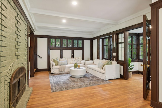 living room featuring light wood-type flooring, a fireplace, and a healthy amount of sunlight