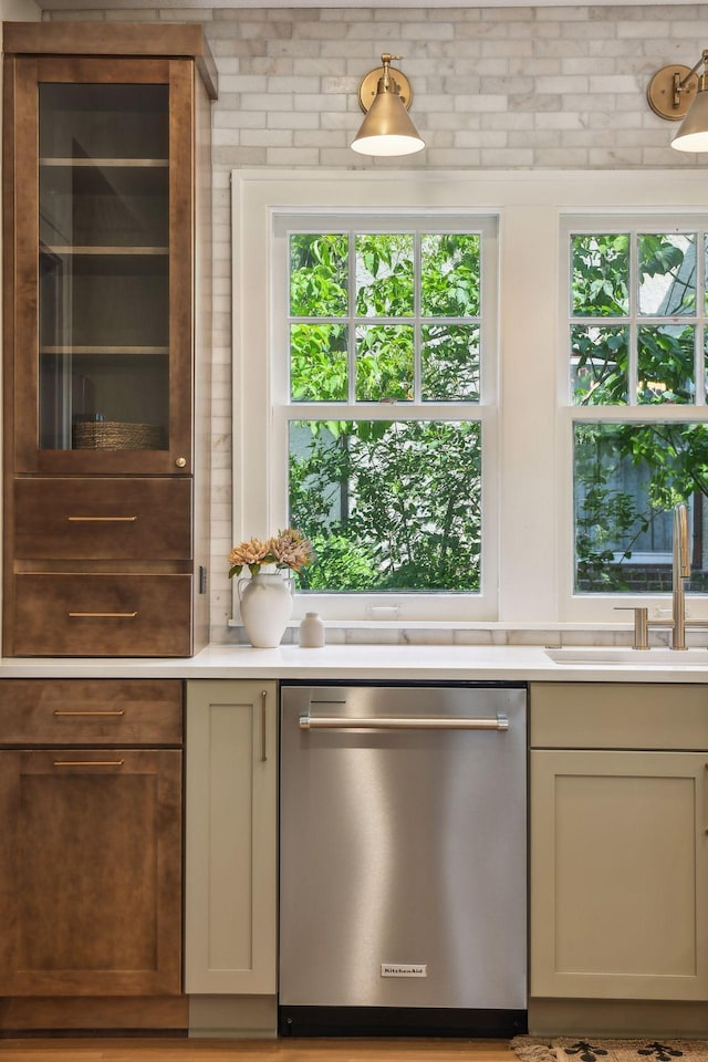 kitchen with dishwasher, sink, and brick wall