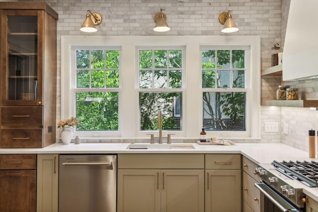 kitchen with appliances with stainless steel finishes, decorative backsplash, cream cabinets, and sink