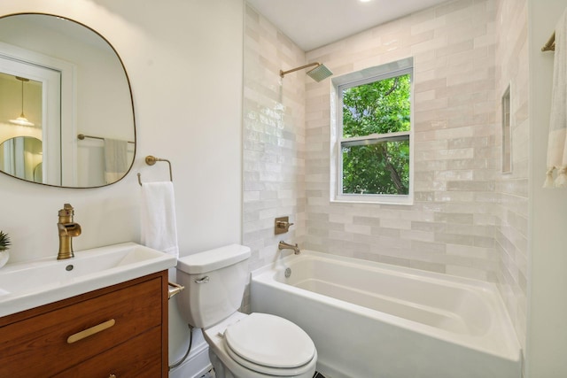 full bathroom featuring tiled shower / bath combo, vanity, and toilet