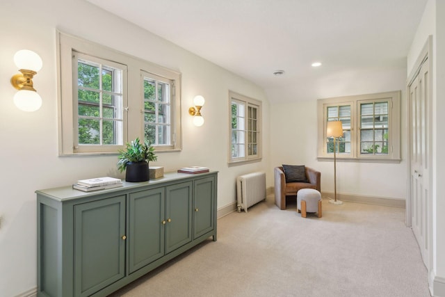 sitting room with radiator and light carpet