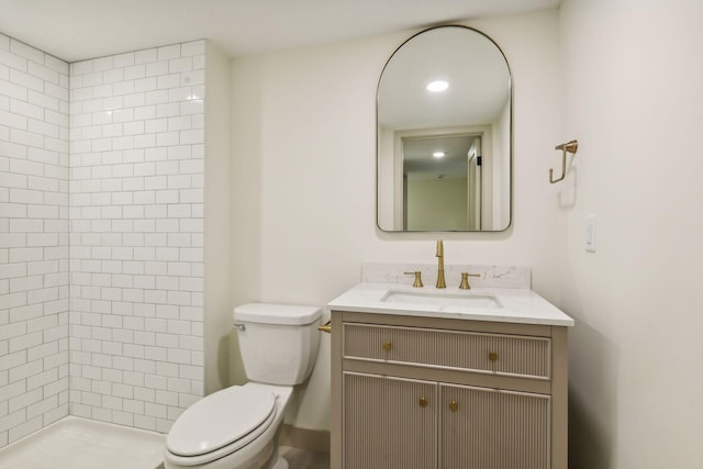 bathroom featuring vanity, toilet, and tiled shower