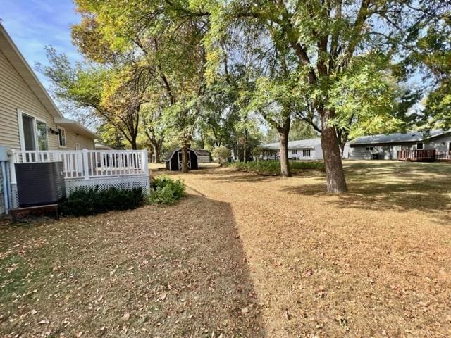 view of yard featuring a wooden deck and a shed