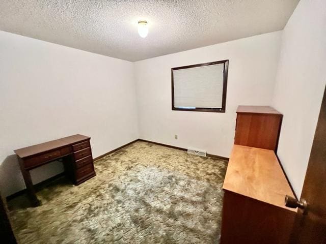 spare room featuring a textured ceiling and carpet flooring