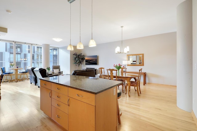 kitchen with light wood-style flooring, pendant lighting, open floor plan, and a center island