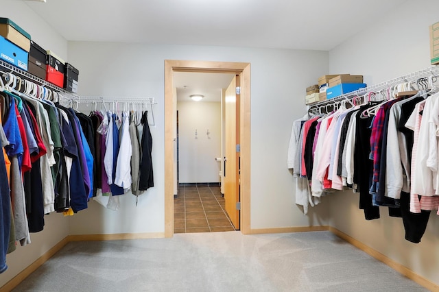 walk in closet with carpet floors and tile patterned flooring