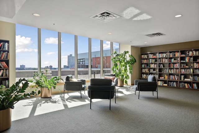 interior space with bookshelves, a view of city, visible vents, and carpet flooring