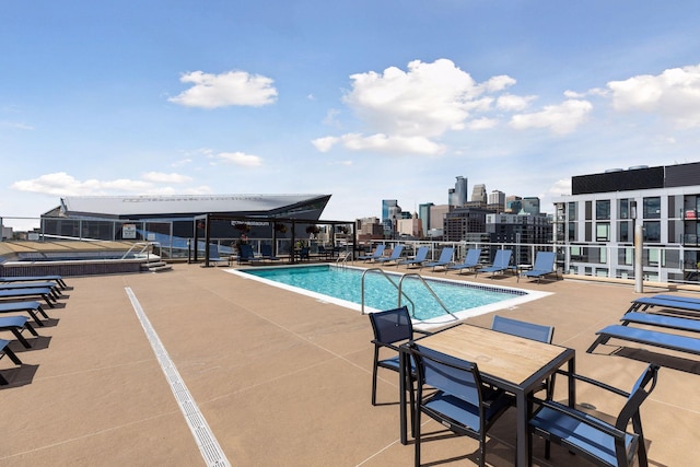 pool with a view of city and a patio area