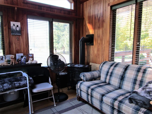 living room with a wood stove, wood walls, and light colored carpet