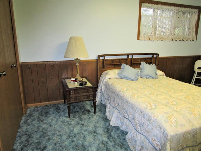 bedroom featuring carpet flooring and wood walls