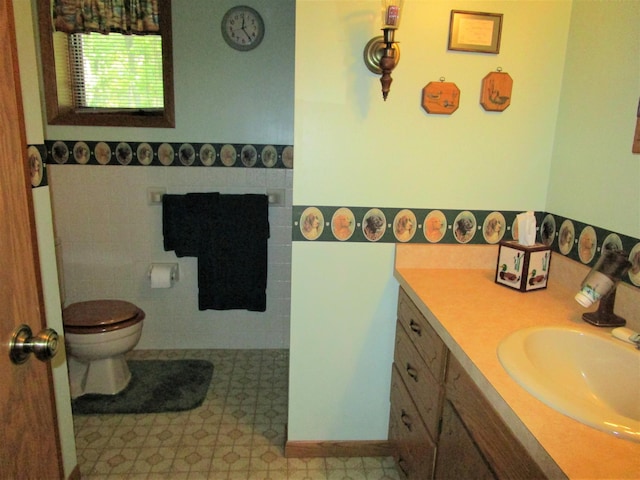 bathroom featuring vanity, toilet, and tile walls