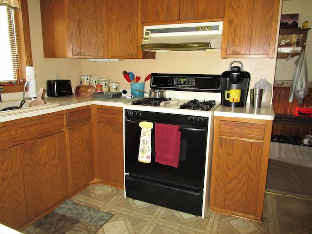 kitchen featuring kitchen peninsula, sink, and white range with gas stovetop