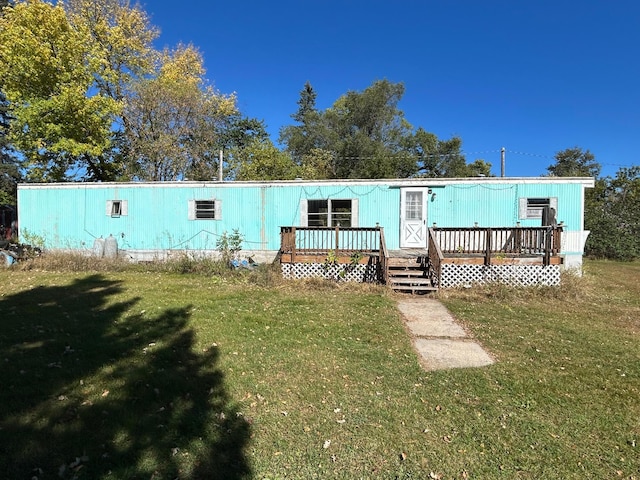 rear view of property with a deck and a yard