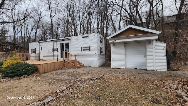 view of front of house featuring a deck and an outbuilding