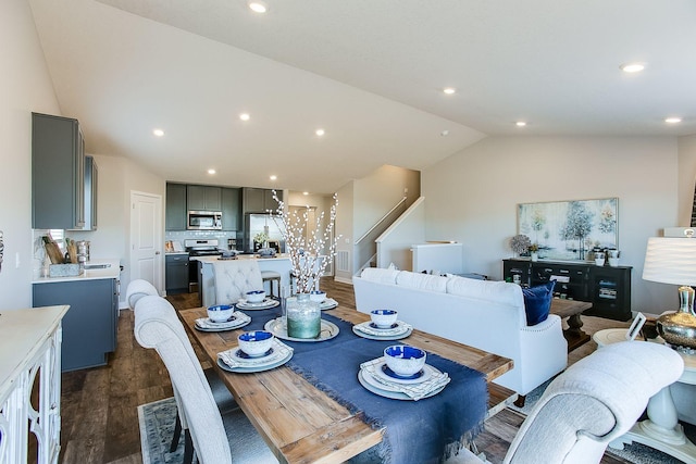 dining room with vaulted ceiling and dark wood-type flooring