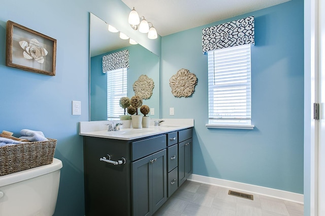 bathroom featuring vanity, toilet, and a wealth of natural light