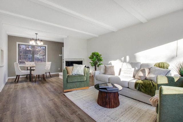 living room featuring a chandelier, beamed ceiling, and dark wood-type flooring