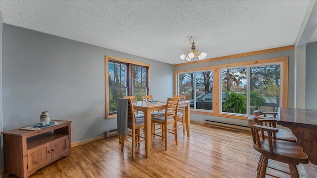 dining space featuring light hardwood / wood-style flooring, a textured ceiling, and plenty of natural light