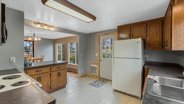 kitchen featuring sink, light tile patterned flooring, pendant lighting, a chandelier, and white appliances