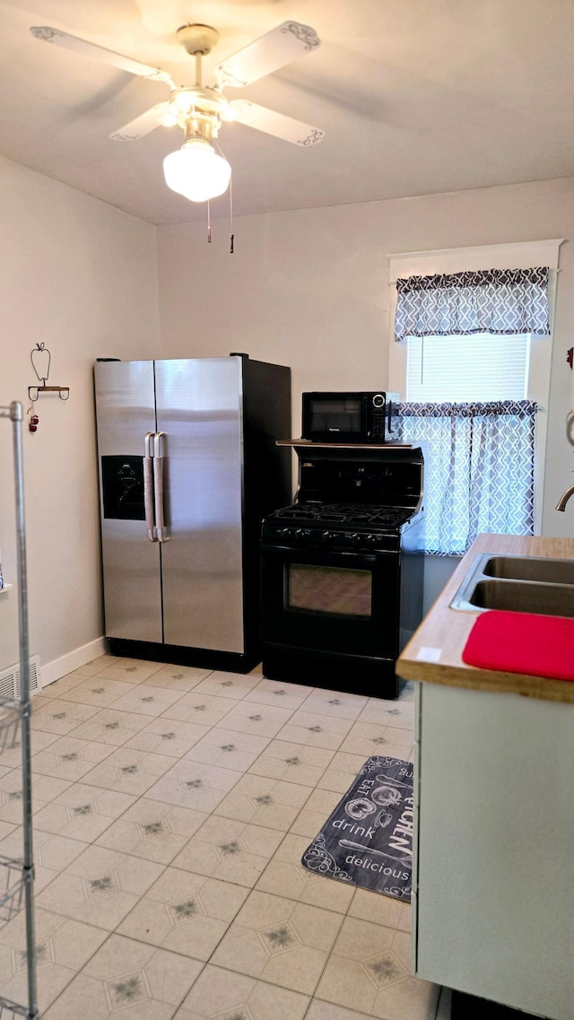 kitchen featuring ceiling fan, sink, and black appliances