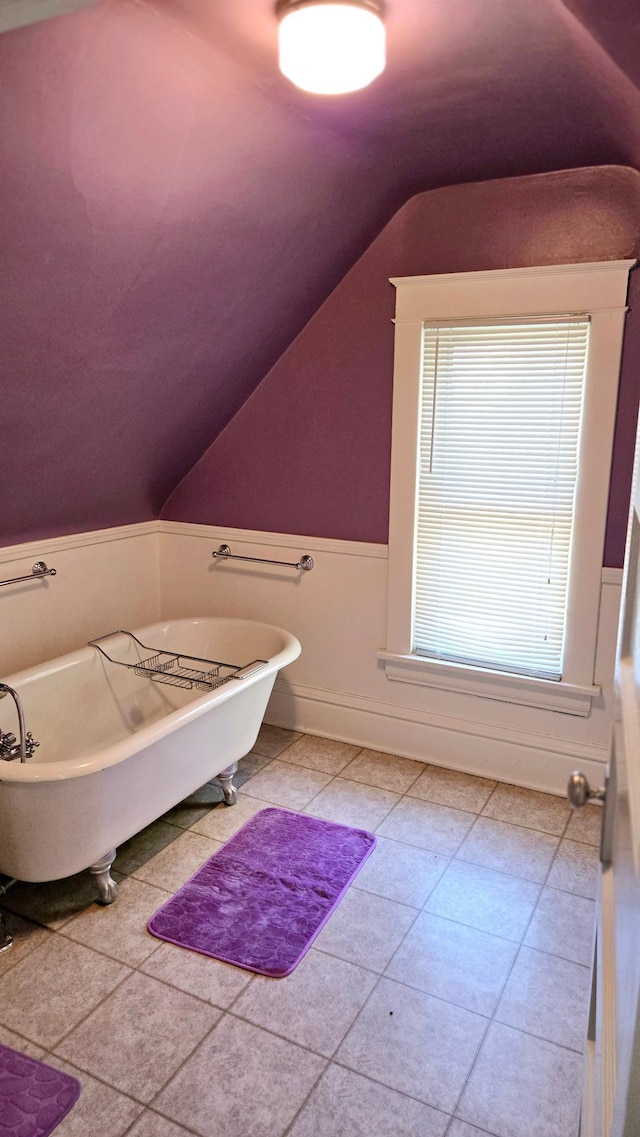 bathroom with a bathing tub and vaulted ceiling