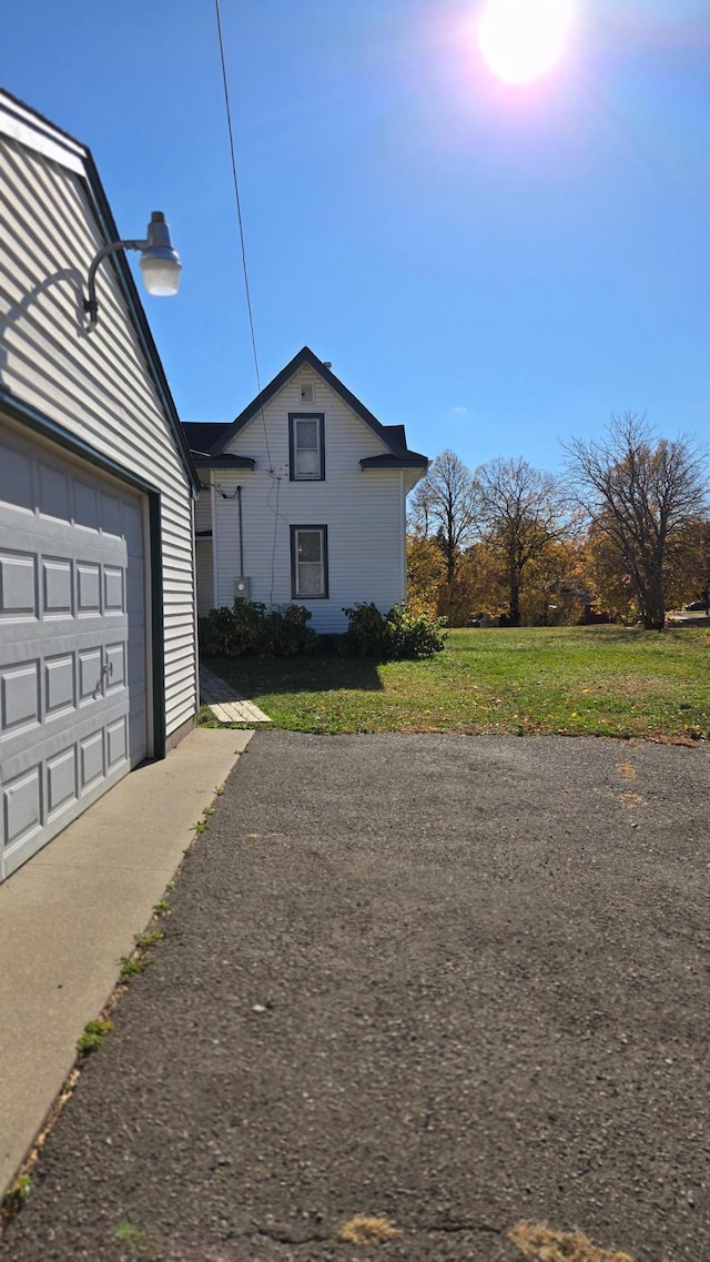 property exterior at dusk featuring a garage and a yard