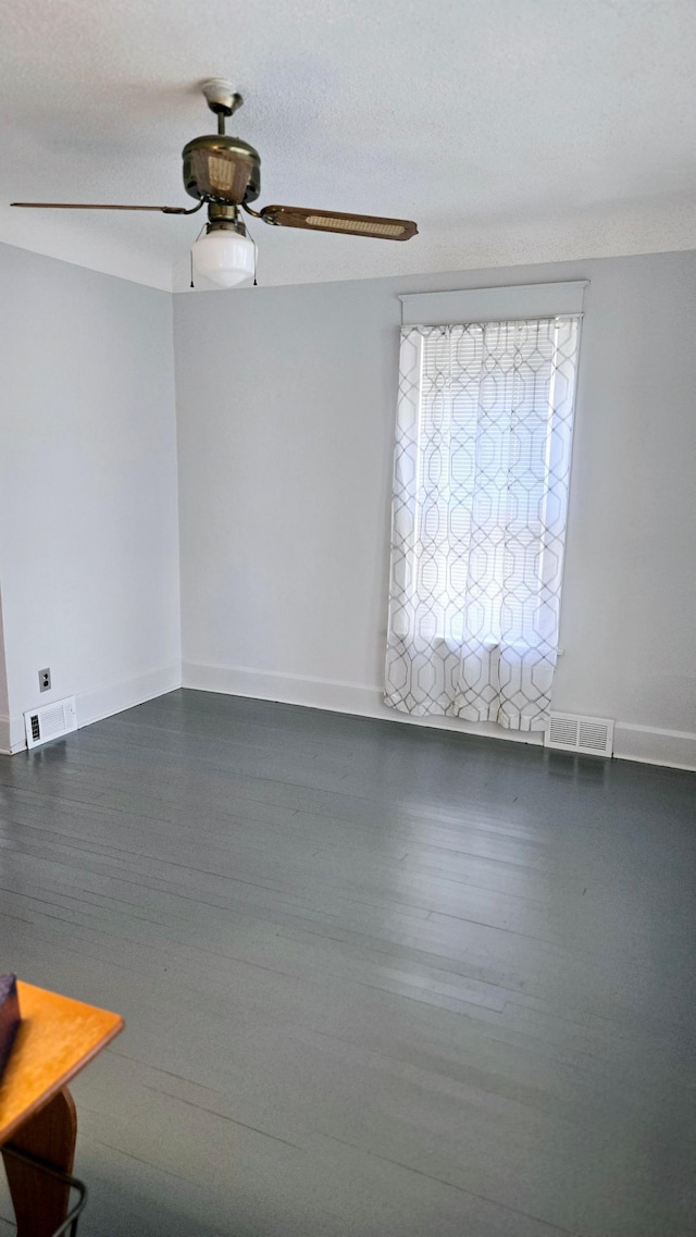 spare room featuring dark hardwood / wood-style flooring, a textured ceiling, and ceiling fan