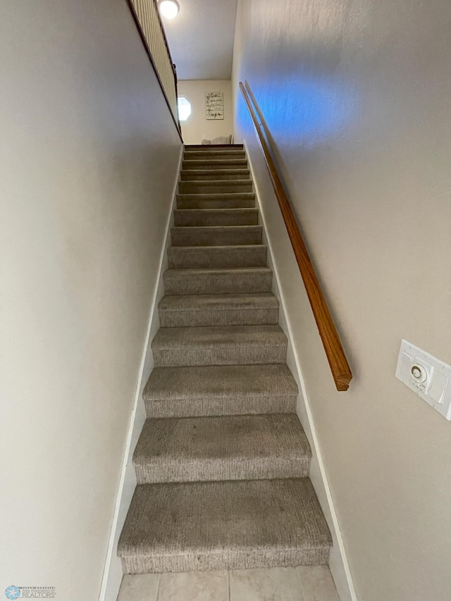 stairway featuring tile patterned flooring