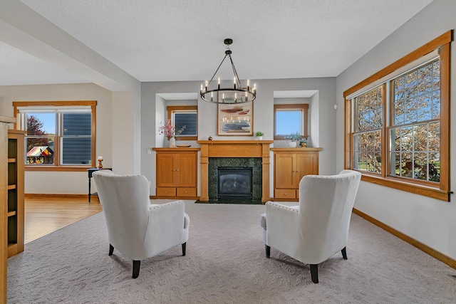2008 11th St N, Sartell, MN 56377 - carpeted living area with baseboards, a chandelier, a fireplace with flush hearth, and a textured ceiling