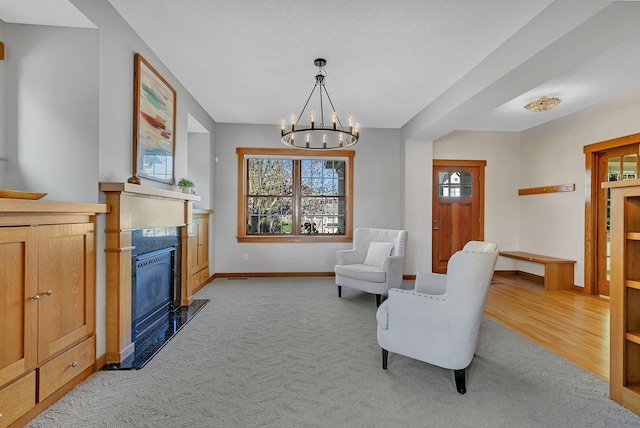 2008 11th St N, Sartell, MN 56377 - sitting room featuring light carpet, a glass covered fireplace, baseboards, and a chandelier