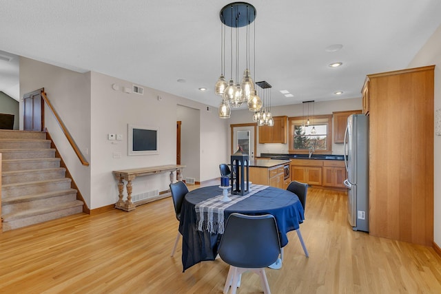 2008 11th St N, Sartell, MN 56377 - dining area featuring light wood-type flooring, a chandelier, recessed lighting, stairs, and baseboards