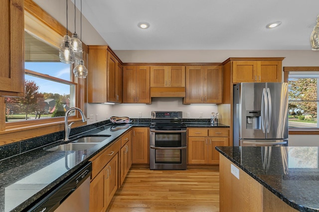 2008 11th St N, Sartell, MN 56377 - kitchen featuring appliances with stainless steel finishes, a sink, brown cabinets, light wood-style floors, and decorative light fixtures