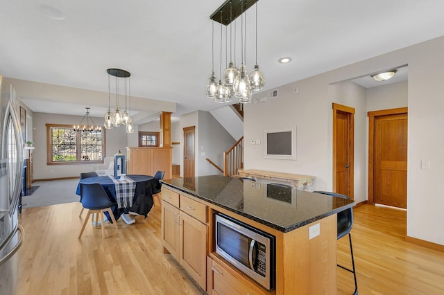 2008 11th St N, Sartell, MN 56377 - kitchen with stainless steel appliances, a chandelier, a kitchen bar, baseboards, and recessed lighting