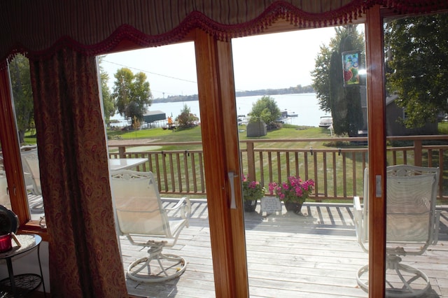 doorway to outside with a water view, hardwood / wood-style flooring, and a wealth of natural light