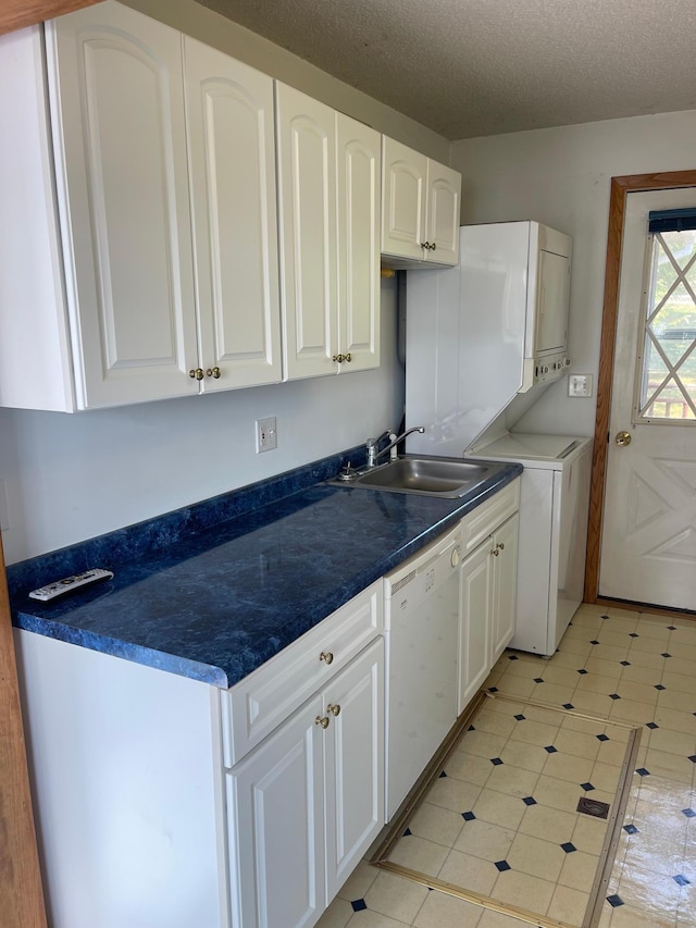 kitchen with white cabinets, white dishwasher, sink, and a textured ceiling