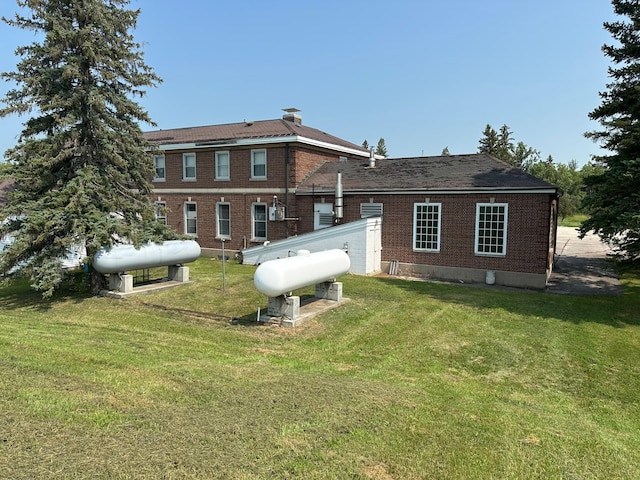 rear view of property featuring a lawn