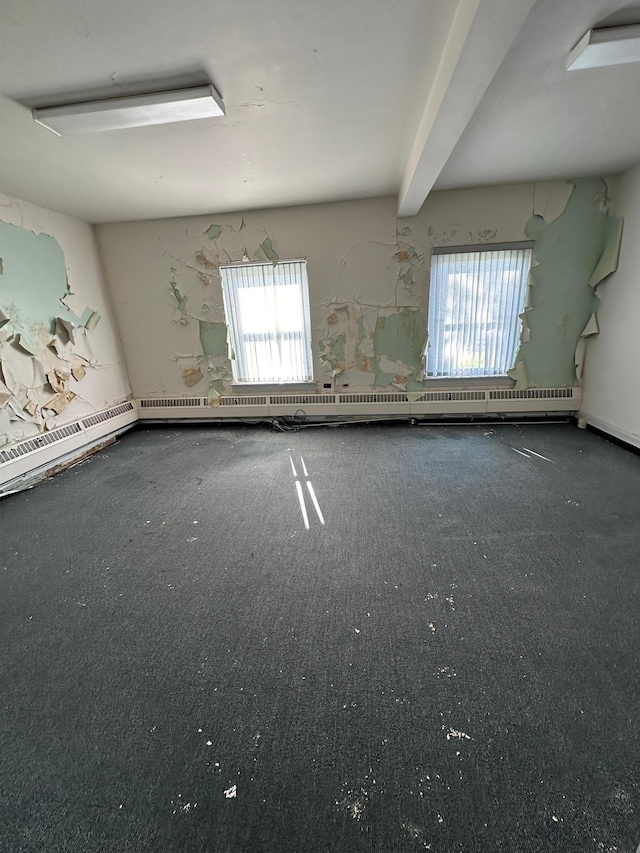 empty room featuring beam ceiling and a wealth of natural light