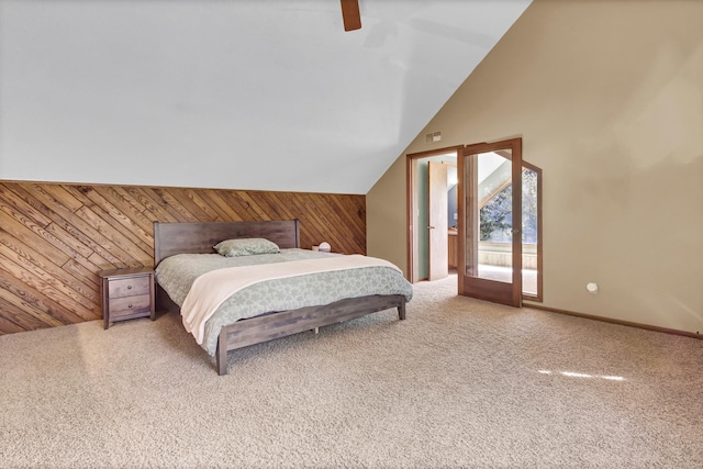 bedroom with access to outside, carpet flooring, wood walls, and ceiling fan