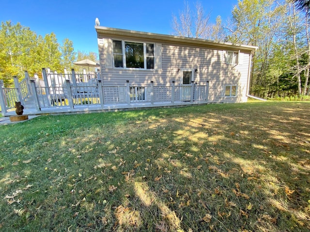 back of house featuring a lawn and a deck