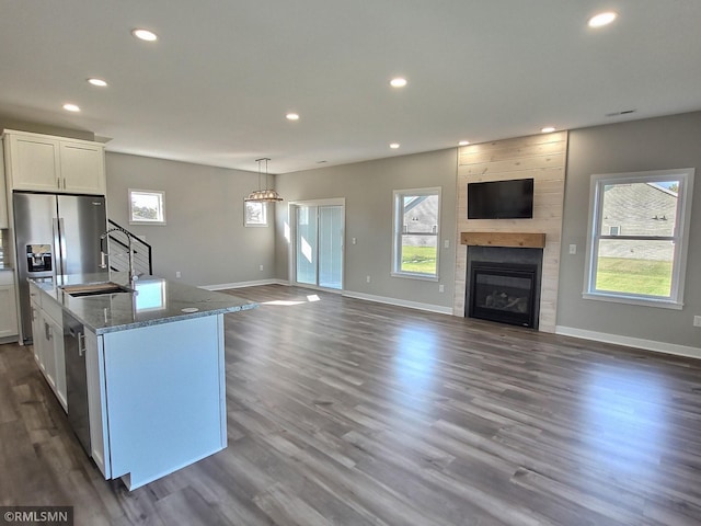 65164 365th St, Watkins, MN 55389 - kitchen featuring a sink, open floor plan, white cabinets, light stone countertops, and recessed lighting
