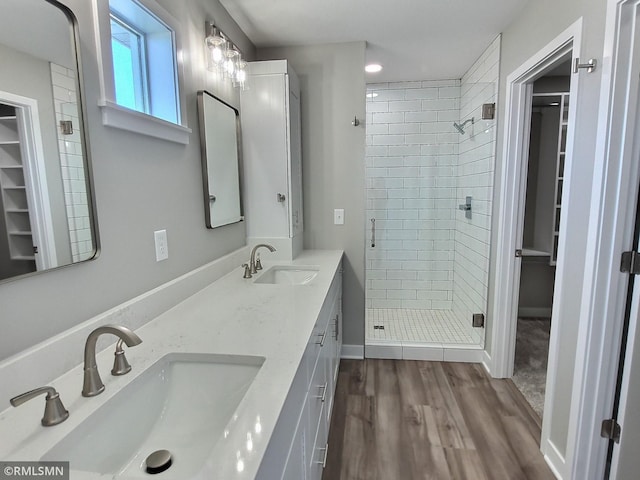 bathroom with a shower with shower door, vanity, and hardwood / wood-style flooring