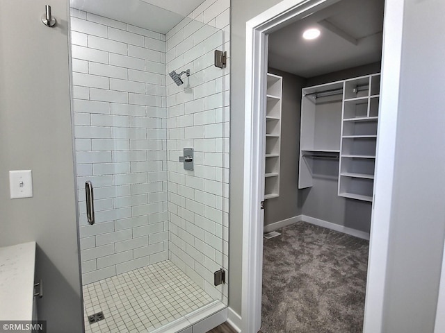 bathroom with a shower with shower door and vanity