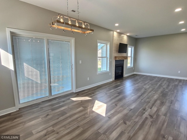 unfurnished living room with dark hardwood / wood-style floors and a tile fireplace