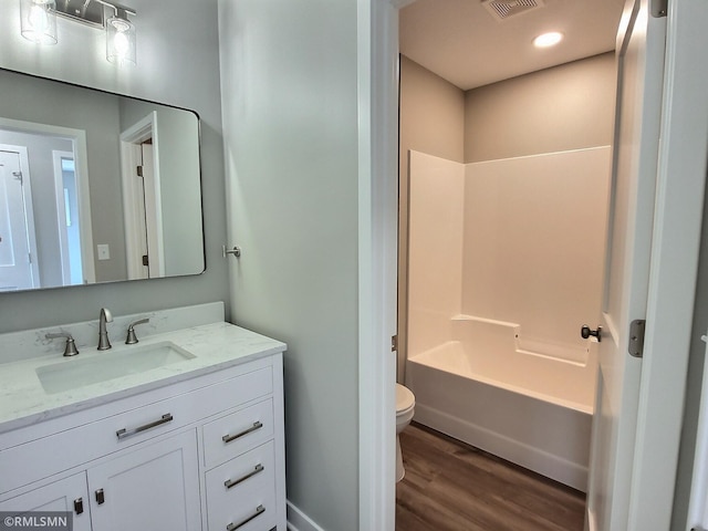 65164 365th St, Watkins, MN 55389 - bathroom with toilet, wood finished floors, visible vents, vanity, and shower / bathtub combination