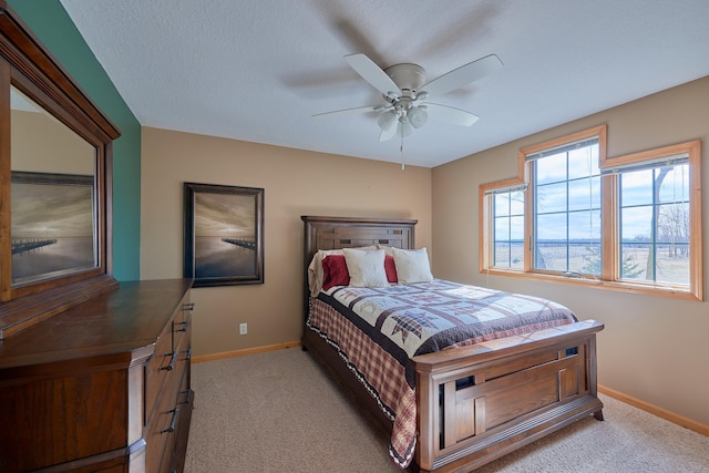 bedroom with ceiling fan, a textured ceiling, and light carpet