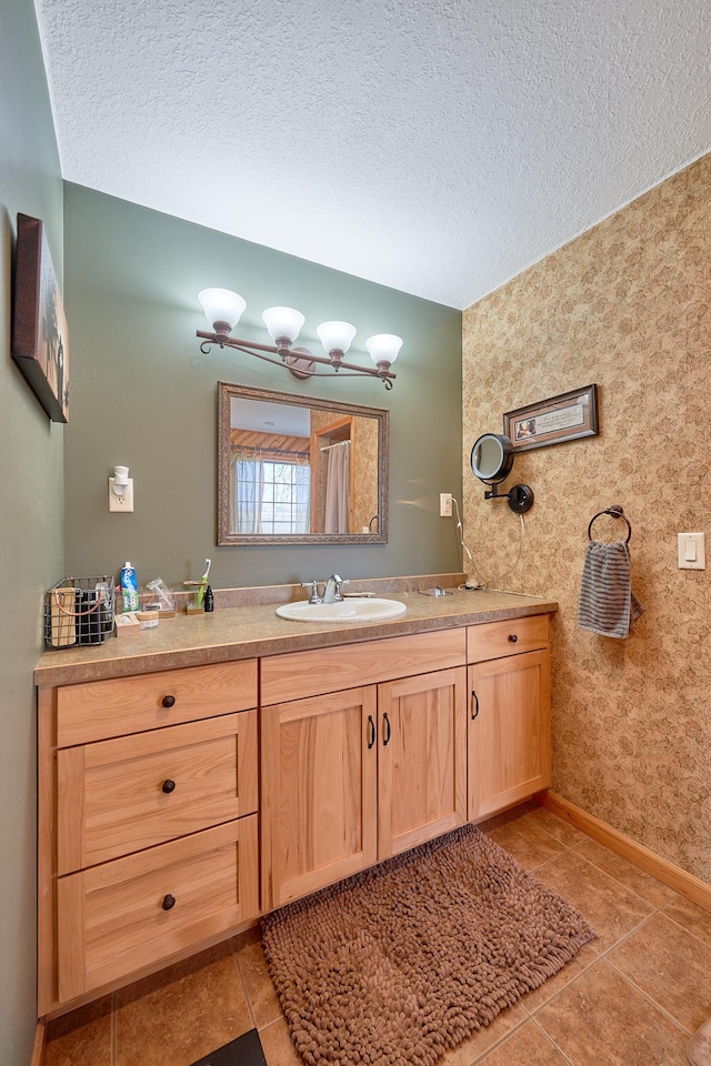 bathroom with tile patterned flooring, a textured ceiling, and vanity