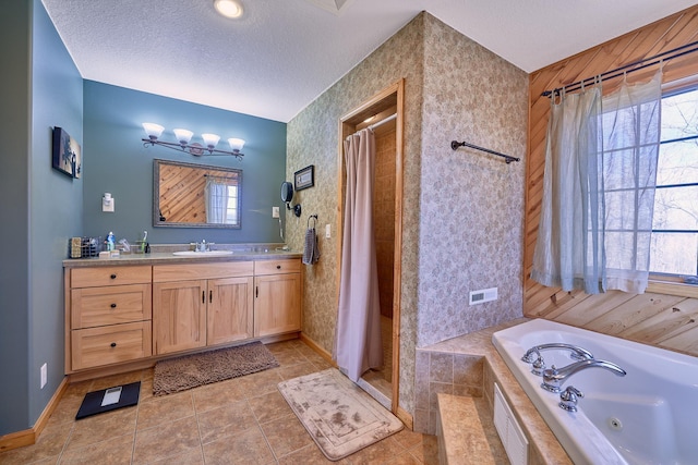 bathroom with a textured ceiling, vanity, separate shower and tub, and plenty of natural light